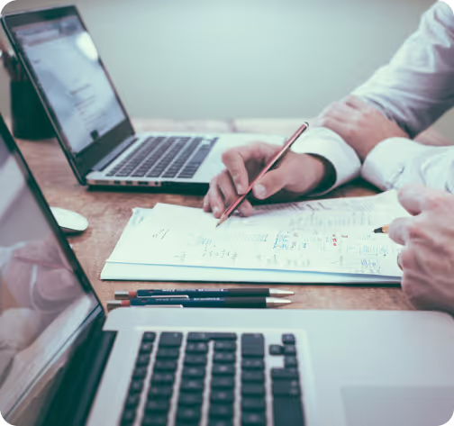 Two men are having a meeting. you can see their hands analysing different graphs.